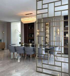 Modern dining room with glass table and gold room divider Modern dining room with glass table and gold room divider