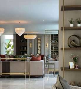 Elegant open-plan living room with plush seating, gold accents, and crystal chandeliers in Hornchurch by Oraanj Interior Design. Elegant open-plan living room with plush seating, gold accents, and crystal chandeliers in Hornchurch by Oraanj Interior Design.