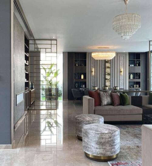 A stunning open-plan living space in Hornchurch, featuring grand chandeliers, rich textures, and sleek built-in shelving expertly designed to exude luxury and comfort. A stunning open-plan living space in Hornchurch, featuring grand chandeliers, rich textures, and sleek built-in shelving expertly designed to exude luxury and comfort.