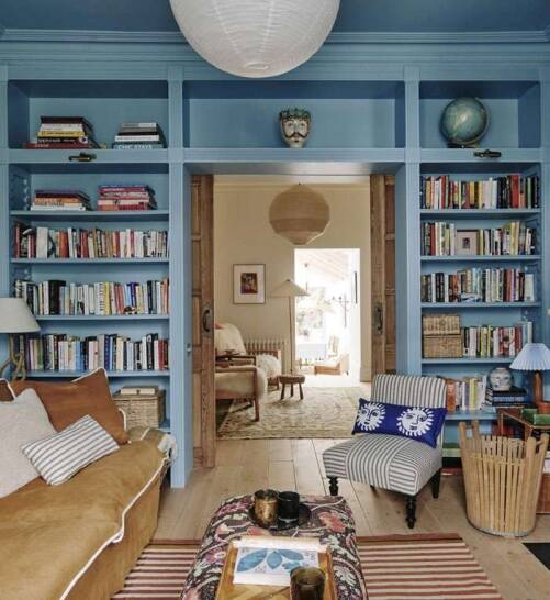 Cosy living room in Whitechapel with built-in blue bookshelves, eclectic furniture, and warm wooden flooring by Oraanj Interior Design. Cosy living room in Whitechapel with built-in blue bookshelves, eclectic furniture, and warm wooden flooring by Oraanj Interior Design.