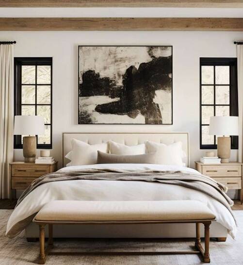A modern bedroom in Dalston featuring a neutral-toned bed, wooden beams, and abstract wall art, designed by Oraanj Interior Design. A modern bedroom in Dalston featuring a neutral-toned bed, wooden beams, and abstract wall art, designed by Oraanj Interior Design.